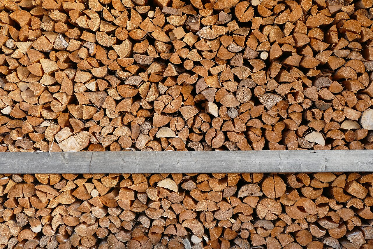 Réserve de bûches de bois de chauffage fendu, empilées et prêtes à la livraison.