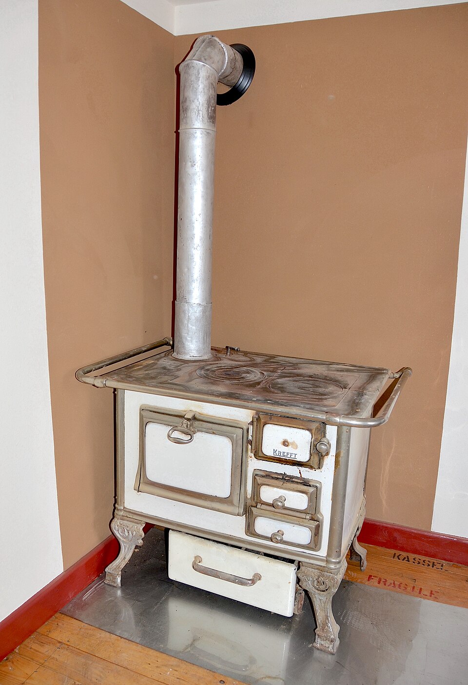 Ancien poêle à bois en fonte utilisé pour la cuisine et le chauffage, avec sa surface en métal patinée.